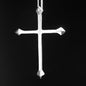 Silver cross pendant on a black background