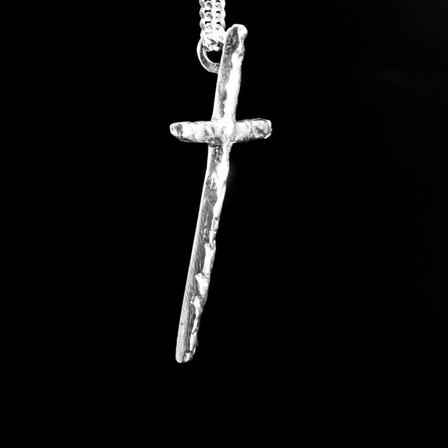 Silver cross pendant on a black background