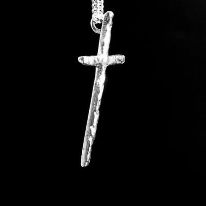 Silver cross pendant on a black background