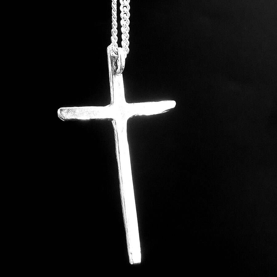 Silver cross pendant on a black background