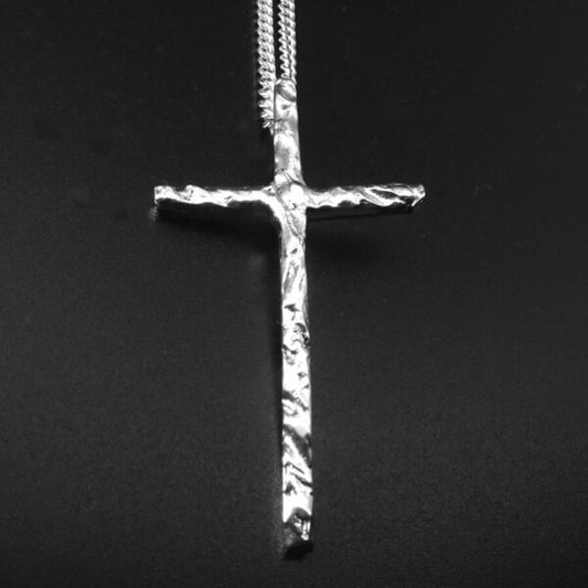 Silver cross pendant on a black background