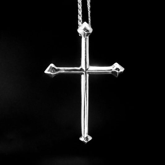 Silver cross pendant on a black background