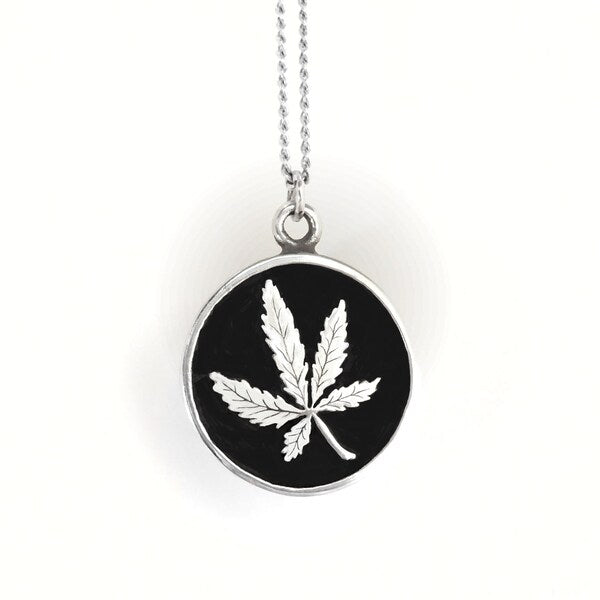Necklace with a black pendant featuring a white leaf design on a white background