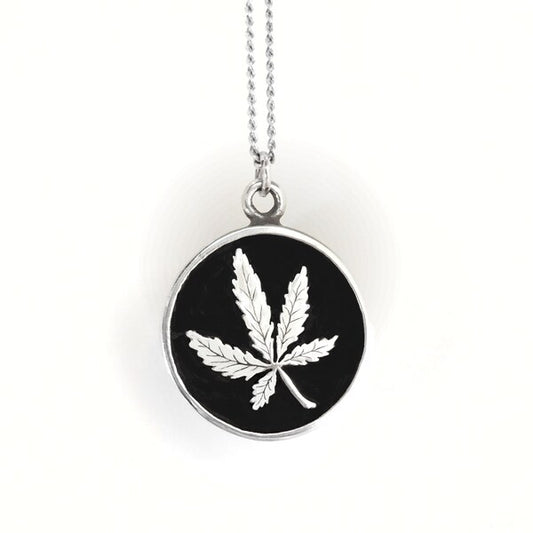 Necklace with a black pendant featuring a white leaf design on a white background