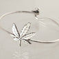 Silver bracelet with a cannabis leaf charm on a light gray background