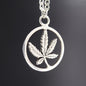 Silver pendant with a cannabis leaf design on a dark background